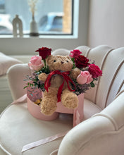 Load image into Gallery viewer, Teddy bear and flowers in a pink box on a white chair 
