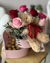 Load image into Gallery viewer, Teddy bear with flowers and a pink box on a wooden table
